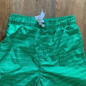 Bright green kids swim shorts with white stripes